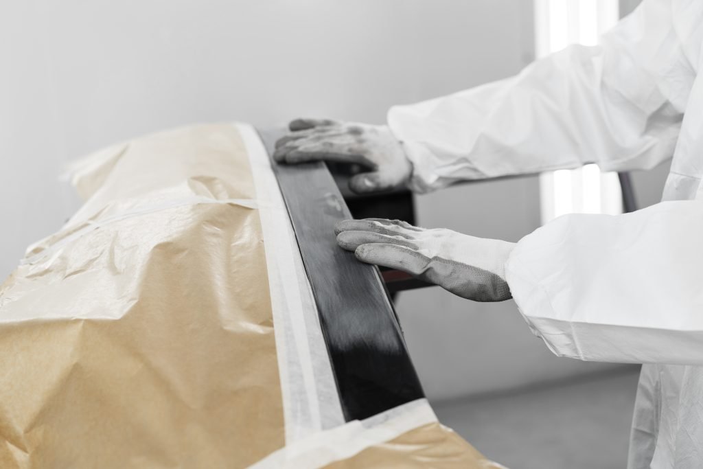 male painter using gun paint car shop